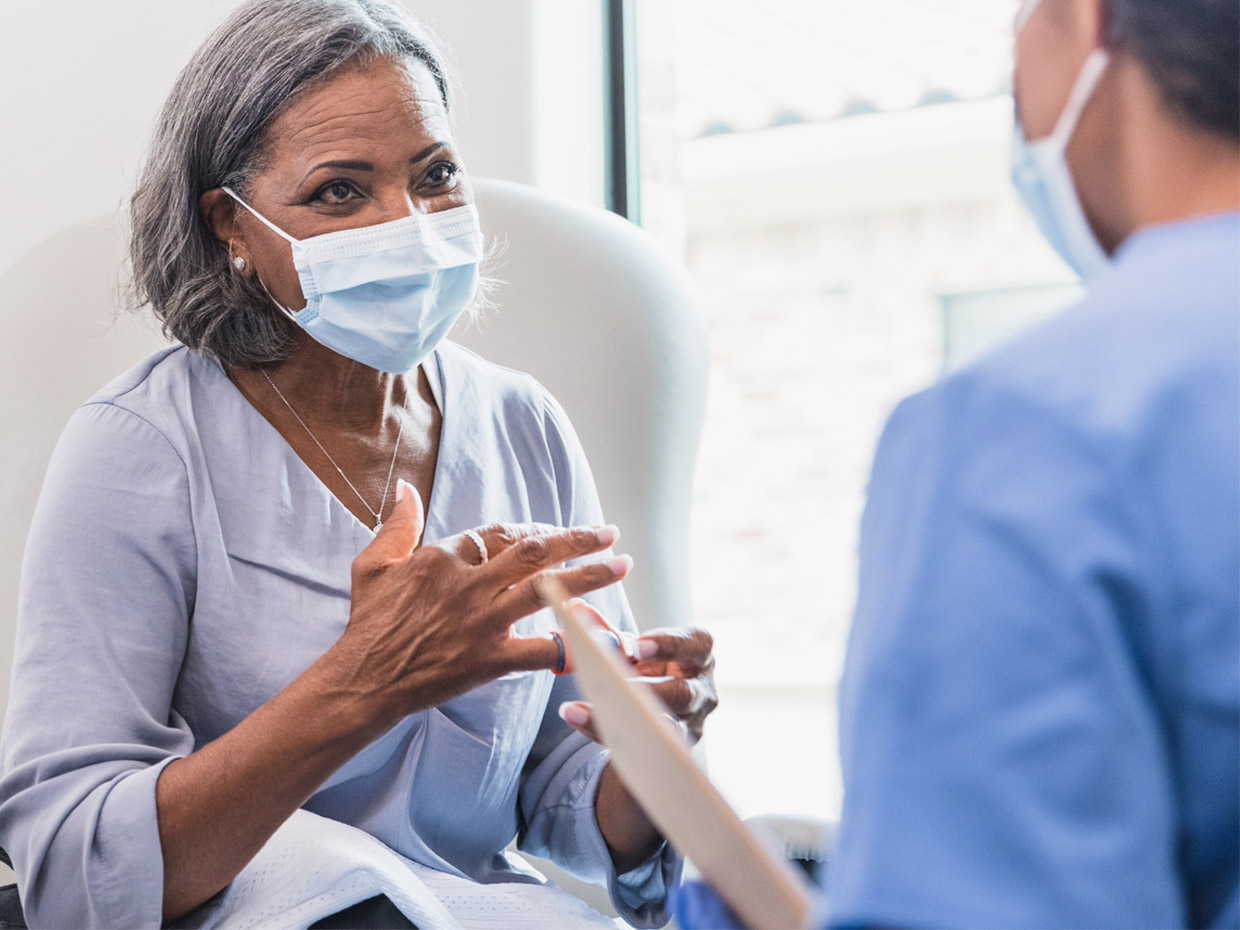 Patient portant un masque et parlant à leur soignant