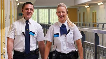 Male and female Sodexo prison officer walking