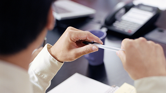 Zoom on person holding a pen