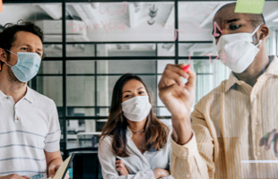 Three people in masks solving a problem