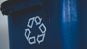 White recycle logo on blue bin