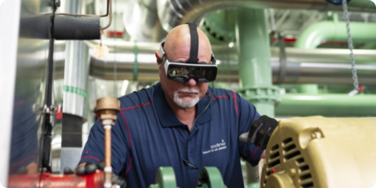 Engineer looking at a boiler with protective glasses on 