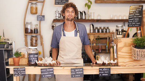 Male barista standing behind counter