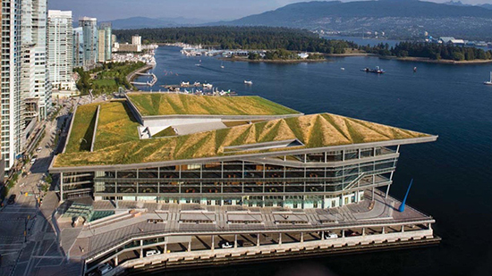 Conference center with grass on the roof next to a lake